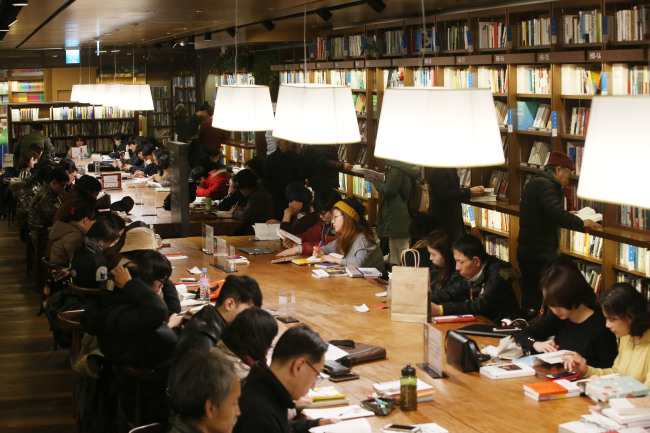 Visitors sit down to read books at the Kyobo Book Center in Gwanghwamun, Seoul on Jan. 5. (Yonhap)