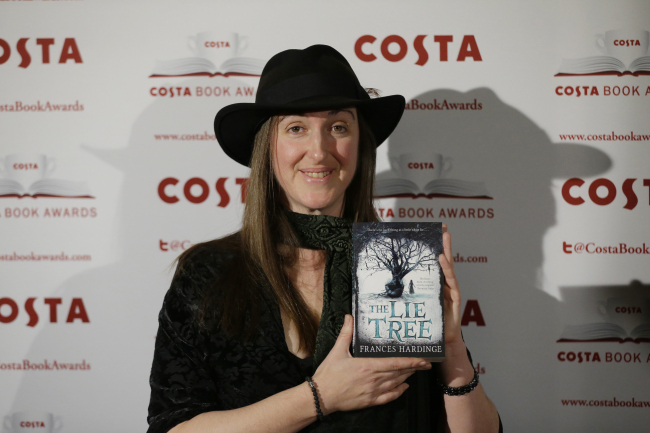 Frances Hardinge poses for photographs with her book ”The Lie Tree“ at the Costa Book Awards in London, Tuesday. (AP-Yonhap)