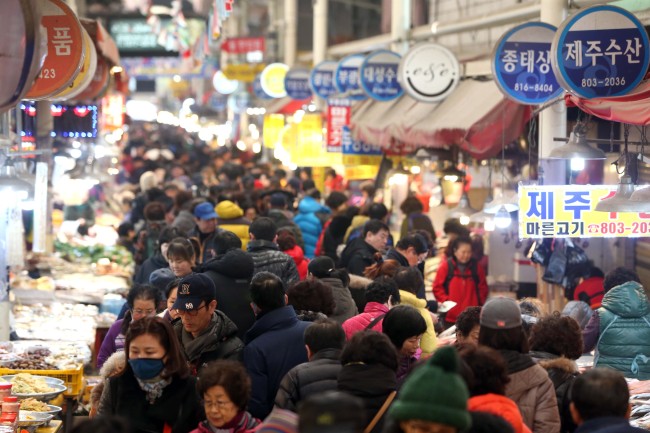 A traditional market in Busan is crowded with shoppers Sunday ahead of the Lunar New Year holiday.    Yonhap