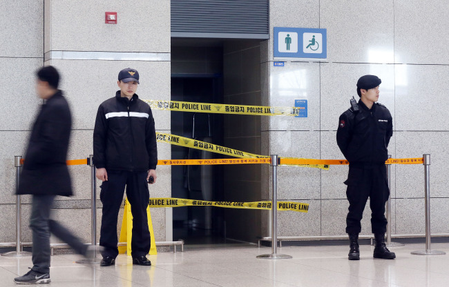 Police stand guard outside a restroom where a suspect package was found along with a threatening message at Incheon International Airport.  Yonhap