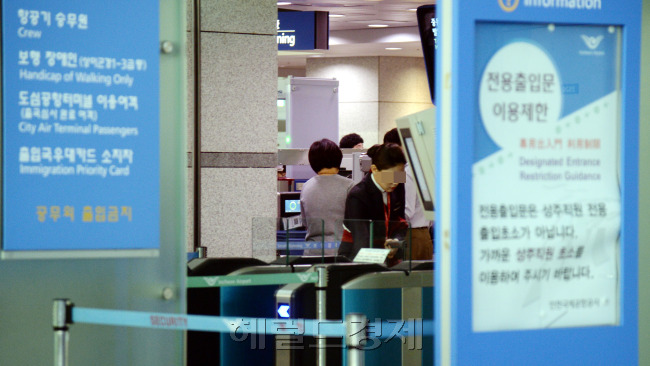 지난달 29일 인천국제공항 입국 심사장을 뚫고 밀입국한 뒤 종적을 감춘 베트남인 A(25) 씨의 자취가 아직까지 오리무중이다. 법무부 출입국관리사무소와 경찰은 서울과 경남 김해 등 베트남인이 다수 거주하는 곳으로 A씨가 숨어들었을 것으로 보고 행적을 쫓고 있다. 1일 인천 중구 인천공항 출국 심사장 문 사이로 공항 직원들이 출국하는 승객들을 살피고 있는 모습이 보이고 있다. 인천=박현구 기자/phko@heraldcorp.com