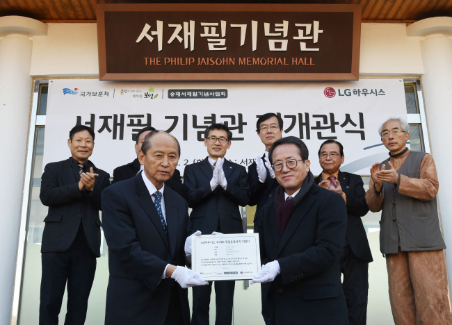 LG하우시스가 2일 전남 보성군 서재필 기념공원에서 ‘서재필 기념관’ 재개관식을 가졌다. 김중채 서재필기념사업회 이사장(앞줄 왼쪽)과 이교목 LG하우시스 상무(앞줄 오른쪽)이 기념현판을 들어보이고 있다. [사진 제공=LG하우시스]