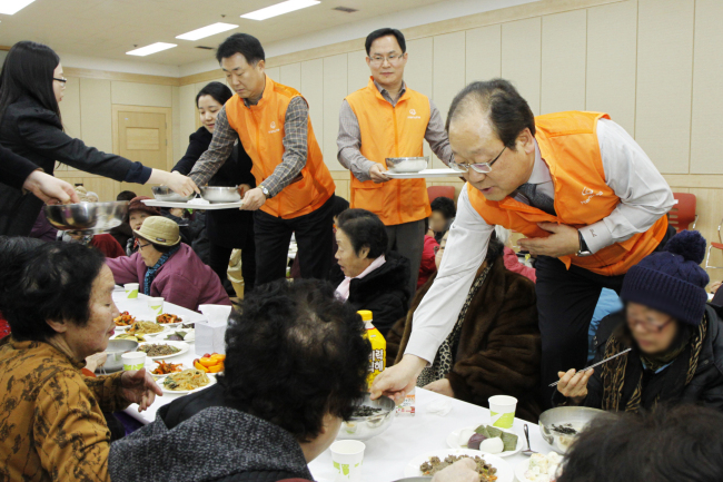 HANWHA’S NEW YEAR CHARITY — Hanwha Corp. CEO Choi Yang-soo (right) and company officials deliver tteokguk, or rice cake soup, to elderly citizens at the Yurak Community Welfare Center in Sindang-dong, Seoul, Thursday. The firm also delivered lunchboxes to senior citizens living alone in the area as part of its charity efforts ahead of the Lunar New Year, known as Seollal in Korean. (Hanwha Group)