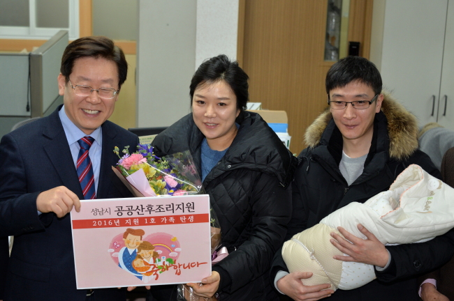 Seongnam Mayor Lee Jae-myeong poses with the first family that benefited from the city’s free postnatal care program. (Seongnam City)