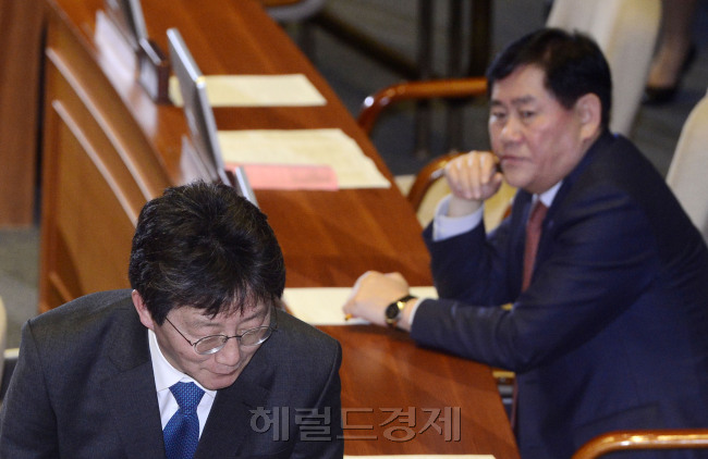 유승민과 최경환. 대구에서 ‘비박’(非박근혜)과 ‘진박’(眞박근혜)의 전면전을 치르고 있는 새누리당의 두 의원이 4일 국회에서 스쳐가듯 만났다. 당의 호출에 모처럼 여의도로 올라와 본회의에 참석했다. 두 사람은 기업활력제고법(원샷법) 등의 법안 표결에 참여했지만, 말을 나누는 모습은 포착되지 않았다. 바로 앞을 지나가는 유 의원의 뒤통수를 고개도 돌리지 않고 옆 눈길로 탐탁치 않은 듯 바라보는 최 의원의 표정이 묘하다. 유 의원의 뒷골이 서늘했을지도 모른다(위). 그러나 같은 자리에서 마주쳤던 두 사람의 1년전은 달랐다. 지난해 2월 3일 임시국회 본회의 교섭단체 대표연설에서 두 사람은 각각 새누리당 원내대표와 경제부총리로 만나 화기애애한 모습으로 당정간의 협력을 약속했던 사이였다.(아래) 이길동·박해묵 기자/gdlee@
