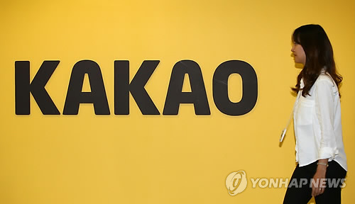 A Kakao employee walks by the Kakao logo at the head office of the mobile messenger firm in Pangyo, Gyeonggi Province. (Yonhap)
