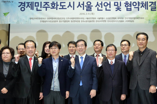 Seoul Mayor Park Won-soon (center) and business representatives pose for a photo after they making “economic democratization” pledges at Seoul City Hall on Thursday. Yonhap