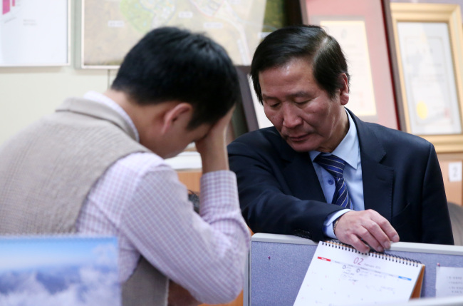 Chung Ki-sup (right), who leads the association of South Korean companies operating in the Gaeseong Industrial Complex in North Kore, converses with an association official in Yeouido, Seoul, Thursday. Yonhap