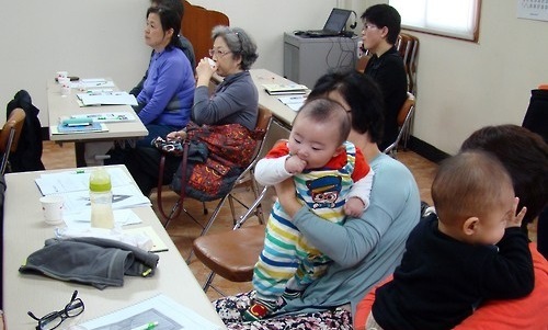 Participants listen to tips on taking care of babies during a class arranged by the Busan office of Korea Population, Health and Welfare Association for grandparents taking care of their grandchildren. (Yonhap)