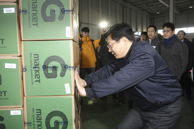 Trade Minister Joo Hyung-hwan tries his hand at locating Gmarket stock at eBay Korea’s overseas logistics center in Incheon on Jan. 21. 　
eBay Korea