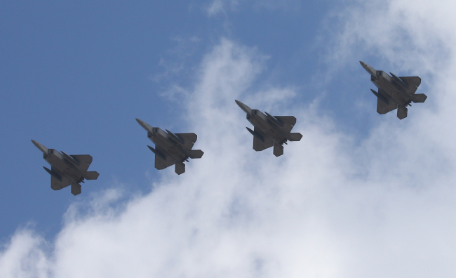 F-22 stealth jets deployed by the U.S. fly over Osan Air Base in Pyeongtaek, Gyeonggi Province, Wednesday. (Yonhap)
