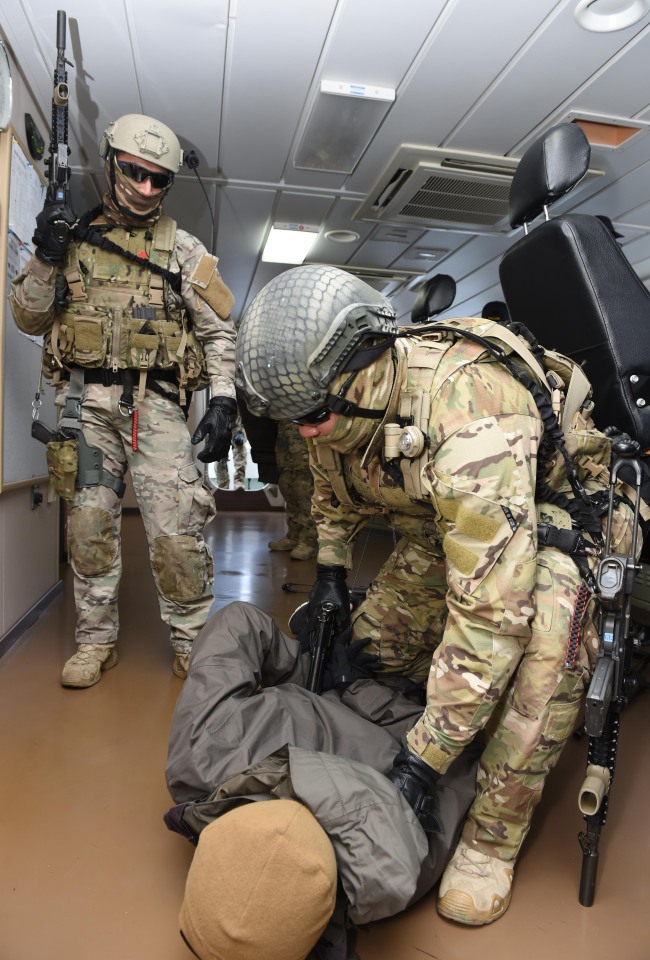 An antiterrorism unit of the UDT/SEAL (Underwater Demolition Team/Sea, Air, Land) of the Navy conducts a drill inside a ship along the east coast on Thursday. (Yonhap)