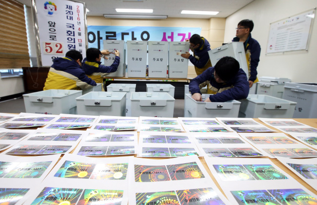 Officials stick identification hologram stickers onto ballot boxes at the election commission office in Suwon, Gyeonggi Province, Sunday. Yonhap
　
