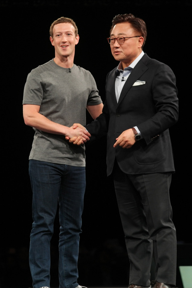 Koh Dong-jin, president of Samsung Electronics’ mobile communications business, and Facebook CEO Mark Zuckerberg shake hands at Samsung’s launch event for the Galaxy S7 and S7 Edge in Barcelona on Sunday. (Samsung Electronics)