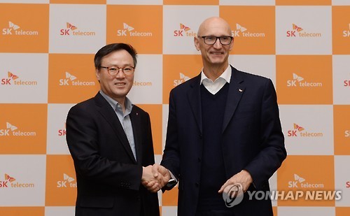 SK Telecom CEO Jang Dong-hyun (left) and Deutsche Telekom CEO Timotheus Hoettges pose at the press meeting in Barcelona on Tuesday. (SKT)