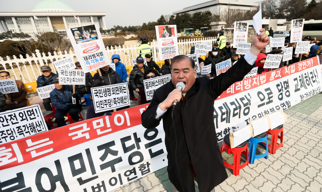 A conservative civic group members hold up placards protesting the opposition‘s filibuster at the National Assembly on Thursday. Yonhap
