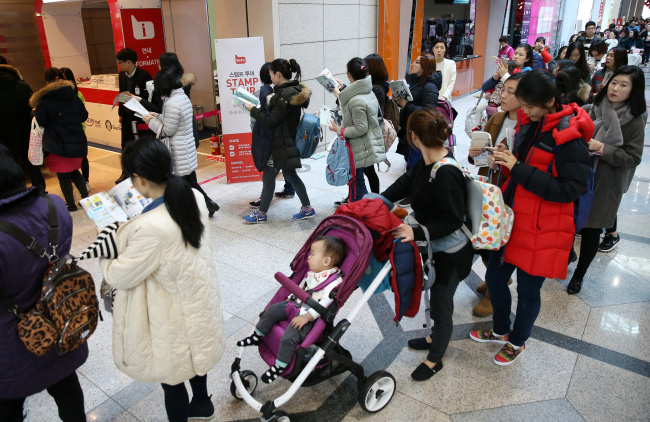 A crowd of people line up Sunday to enter a baby fair held at Coex in Seoul. (Yonhap)