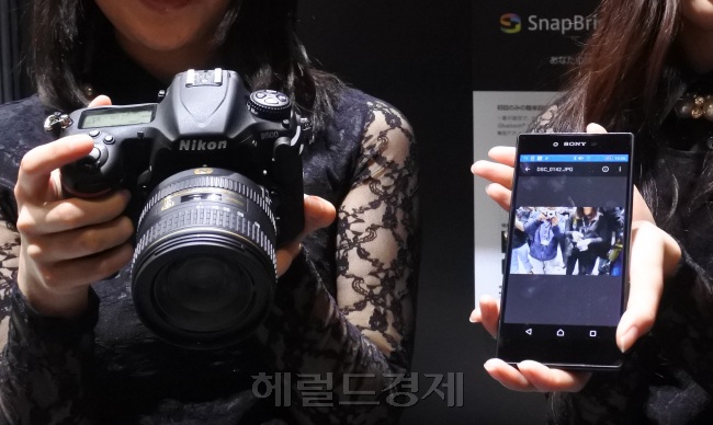 니콘이 CP+2016에서 선보인 스마트폰과 카메라 연동 앱 스냅브리지 시연 모습.