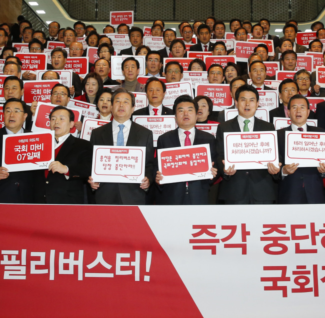 The Saenuri Party lawmakers hold plcards to protest aganist the opposition-led filibuster at tHE National Assembly. Yonhap