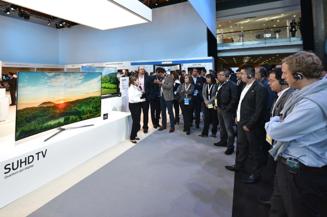 Visitors at the Samsung Electronics’ showcase event in Lisbon, Portugal, in February, look at the tech firm’s latest SUHD TV.  (Samsung Electronics)