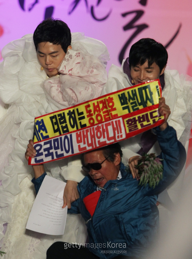 지난 2013년 국내 최초로 열린 김조광수ㆍ김승환 부부의 동성 간 공개 결혼식에서 반대측 회원 한 명이 피켓을 들고 식장에 난입하고 있다. [사진=게티이미지]