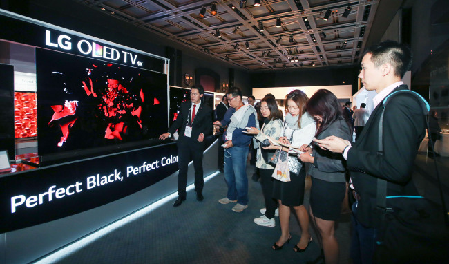 　Global buyers look at LG Electronics’s OLED TV at a showcase event held earlier this year in Korea.
　LGE
　LG Display showcases a rollable display at the International CES trade show held in Las Vegas in January this year.
　LGD