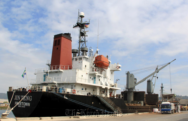 Crewmen of the North Korean cargo vessel Jin Teng stand on the middle of the deck as it unloads its cargo while docked at Subic Bay, northwest of Manila, Friday. (AP-Yonhap)