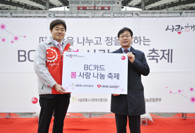 BC카드 장민(왼쪽) 시너지 실장과 사회복지협의회 이수홍 사무총장이 지난 5일 서울 상암월드컵경기장에서 열린 ‘봄 사랑 나눔 축제’에서 기념사진을 촬영하고 있다.