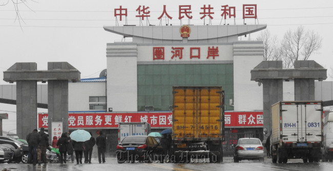 People and vehicles queue as they seek to enter North Korea from Hunchun, Jilin Province, China on Sunday. (Yonhap)