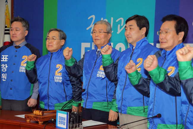The Minjoo Party leadership makes victory gestures while wearing new election campaign jackets at a party meeting on Monday. Yonhap
　