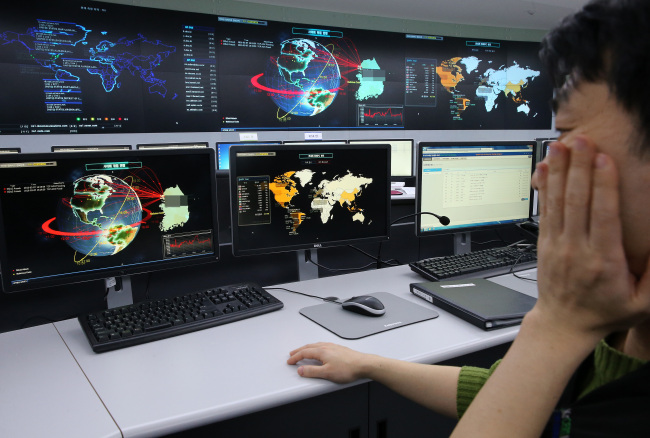 An offical looks at the screen desribing cyber attacks on websites based on Korea. Yonhap