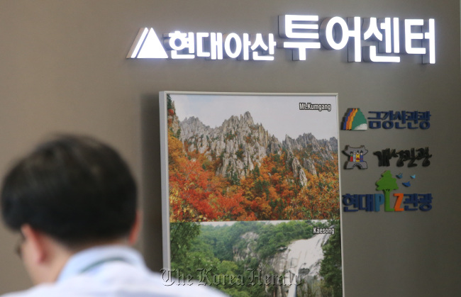 An official is seen at the tour center run by Hyundai Asan Corp. at its headquarters in Seoul on Thursday where images of North Korea's Geumgangsan mountain resort are on display. (Yonhap)