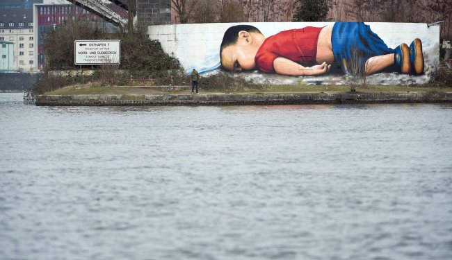 A huge graffiti artwork of Syrian toddler Aylan Kurdi, by Frankfurt artists Justus Becker and Oguz Sen is seen on a wall on the banks of river Main near the headquarters of the European Central Bank in Frankfurt, Germany, on March 10. (EPA-Yonhap)
　
　
