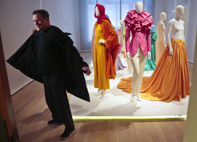 Fashion designer Isaac Mizrahi takes off his jacket as he prepares for a press preview tour of his exhibition at the Jewish Museum on Monday, in New York. (AP-Yonhap)