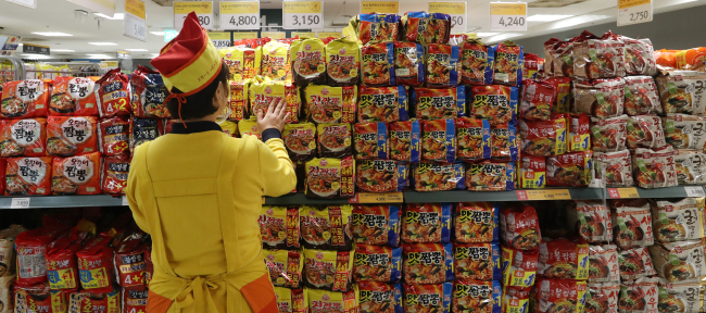 A store manager stacks premium ramen products at a discount supermarket chain in Seoul. (Yonhap)