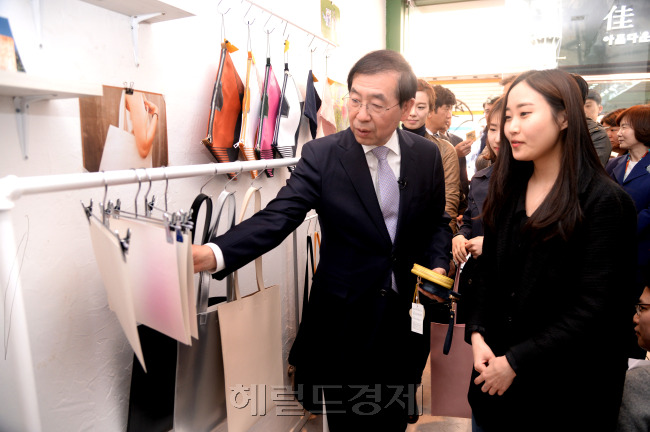 박원순 서울시장이 22일 서강대·연세대·이화여대·홍익대 등 신홍합 지역 4개 대학 총장들과 함께 대학과 지역사회의 상생발전 모델로 손꼽히는 서울 대현동 이화여대 정문 왼쪽 골목 "이화 스타트업 52번가"를 찾아 빈 점포를 빌려 창업한 학생과 이야기하고 있다. 박 시장은 “대학의 다양한 제안을 시정에 적극적으로 반영해 지역과 대학이 상생 발전하고 양질의 청년 일자리로 이어질 수 있도록 하겠다”고 말했다. 박현구 기자phko@heraldcorp.com