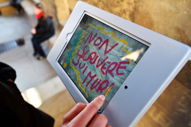 Alice Filipponi, from the Opera di Santa Maria del Fiore, writes a virtual graffiti reading “Do not write on walls” on a tablet screen on March 17 in Florence.  (AFP-Yonhap)