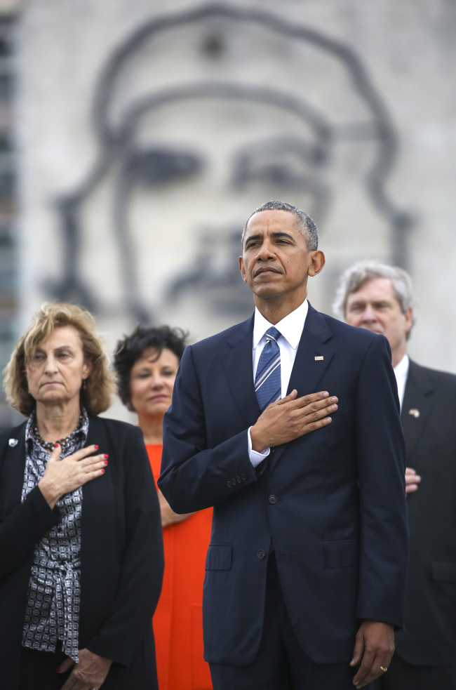 Back-dropped by a monument depicting Cuba's revolution hero Ernesto "Che" Guevara, U.S. President Barack Obama (second from right) listens to the U.S. national anthem during a ceremony at the Jose Marti Monument in Havana on Monday. (AP-Yonhap)