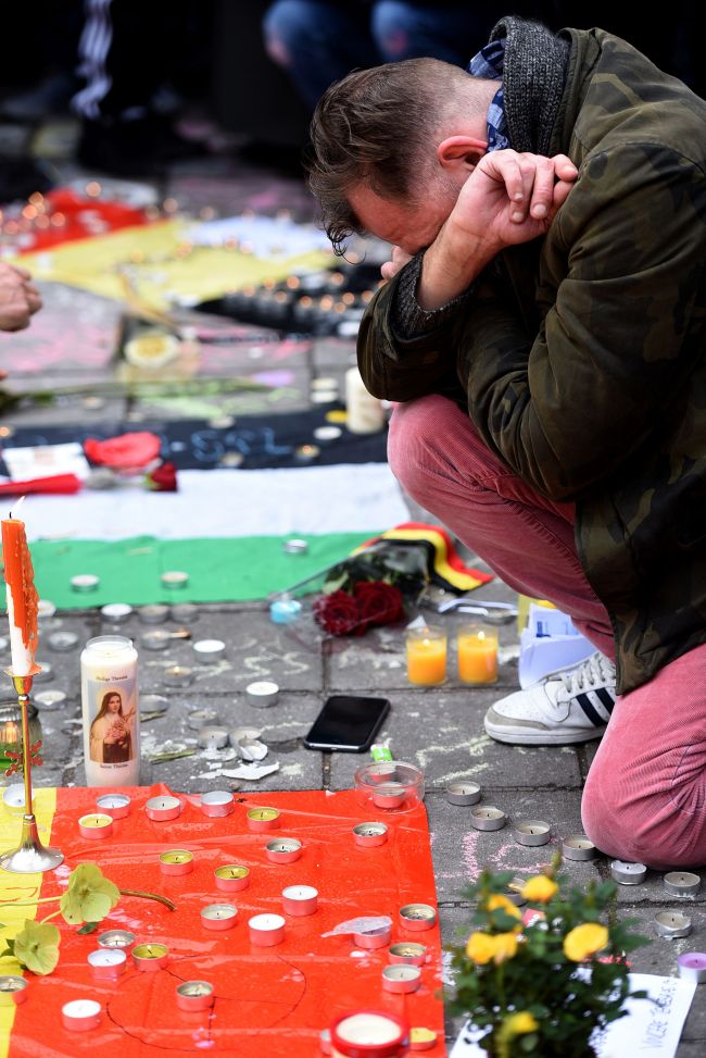 A man reacts as people gather to observe a minute of silence in memory of the victims of the Brussels airport and metro bombings, on the Place de la Bourse in central Brussels, on Wednesday. (AFP-Yonhap)