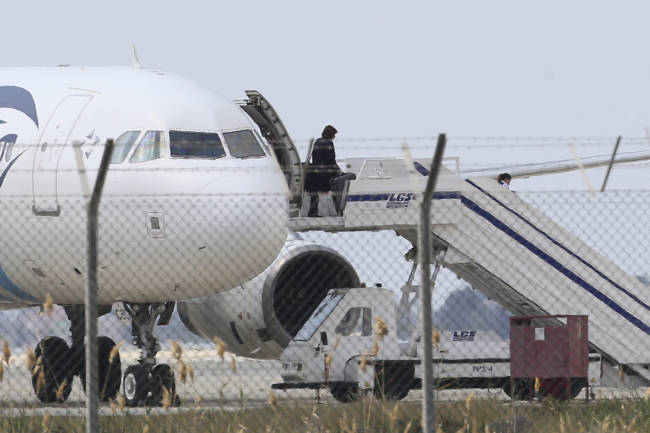 A passenger leaves a hijacked EgyptAir aircraft after landing at Larnaca Airport in Cyprus on Tuesday. (AP-Yonhap)