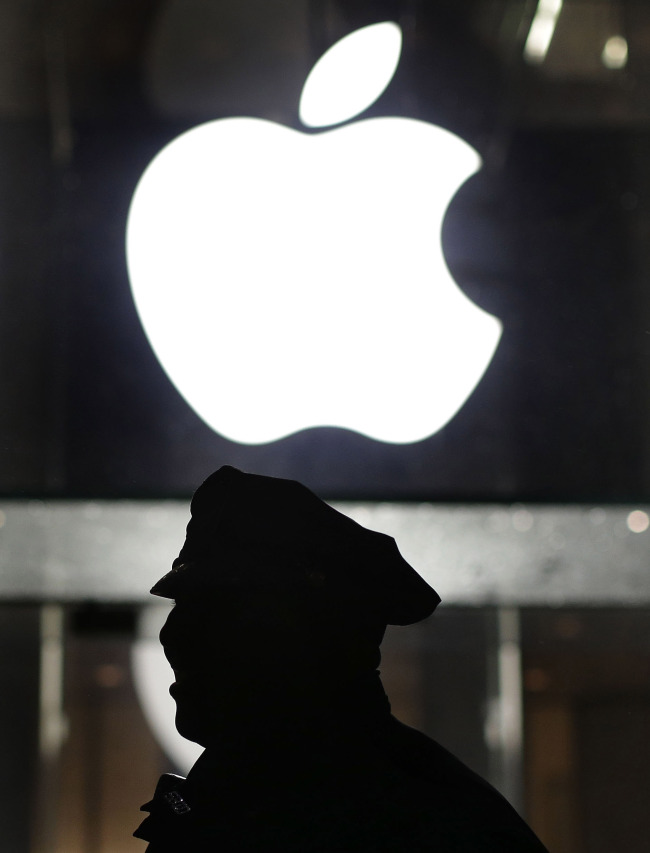 This Feb. 23, 2016, file photo shows a New York police officer stands outside the Apple Store on Fifth Avenue while monitoring a demonstration, in New York. (AP-Yonhap)