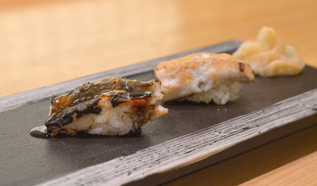 Sushi Matsumoto's anago, salt-water eel, served as a pair, one adorned with a soy sauce-based lacquer (left) and the other with salt and yuzu. (Lee Sang-sub/The Korea Herald)