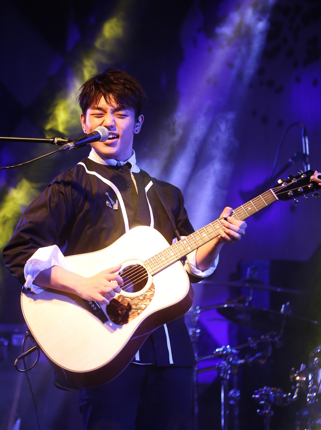Singer-songwriter Sam Kim performs onstage in Itaewon on Monday. (Yonhap)