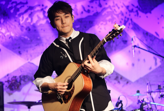 Singer-songwriter Sam Kim performs onstage in Itaewon on Monday. (Yonhap)