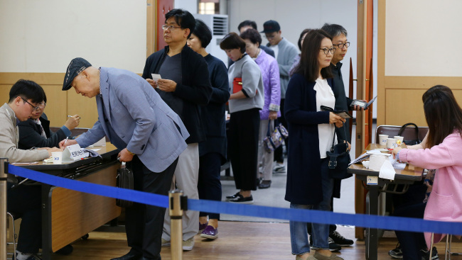 Voters wait in line at a polling station in Jamsil, Seoul, Wednesday. (Yonhap)