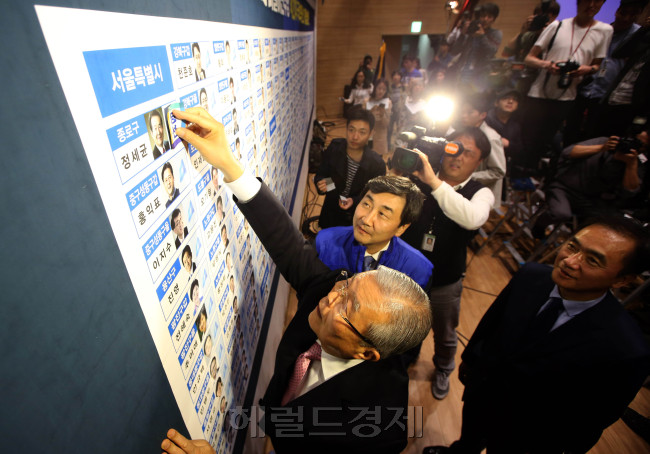 더불어민주당이 4ㆍ13총선에서 원내 제1당과 사실상 유일 전국정당이라는 성과를 올렸다. 김종인 비대위 대표가 13일 밤 국회 의원회관 선거개표 상황실에서 당선확정된 종로 정세균 후보 사진 옆에 당선 스티커를 부착하는 모습. 안훈 기자 rosedale@heraldcorp.com