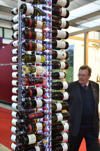 A man walks past a column of wine bottles on April 10 during the 50th edition of the VinItaly wine exhibition in Verona. (AFP-Yonhap)