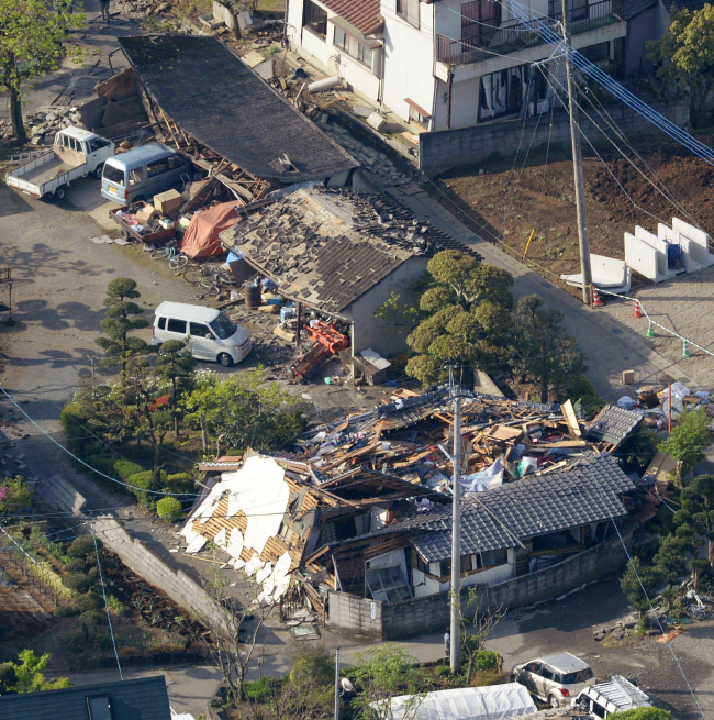 This aerial photo shows houses damaged by a magnitude-6.5 earthquake in Mashiki, Kumamoto prefecture, southern Japan, Friday. The powerful earthquake struck Thursday night, knocking down houses and buckling roads. (AP-Yonhap)