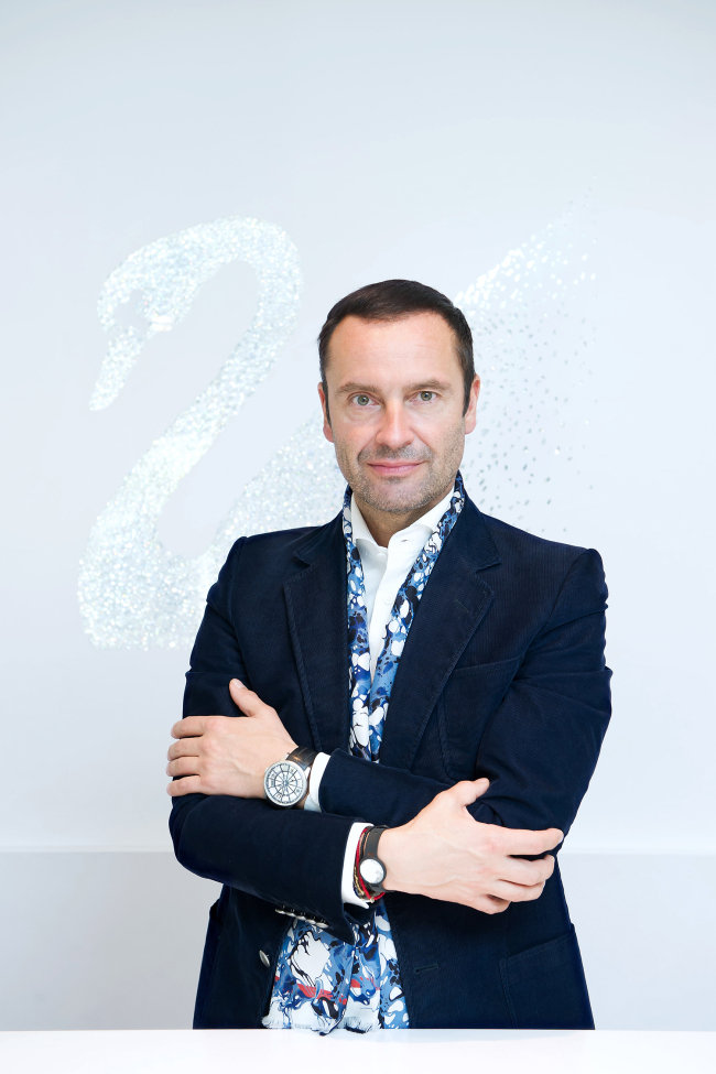 Robert Buchbauer, CEO of Consumer Goods Business of Swarovski, poses in front of the brand’s iconic swan logo at a Swarovski store in Garosugil, Seoul, on Tuesday.(Jang Jong-hoon)