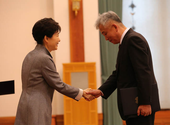 President Park Geun-hye shakes hands with Lee Sang-deok, South Korea’s new ambassador to Singapore, during the appointment ceremony in Cheong Wa Dae on Wednesday. (Yonhap)